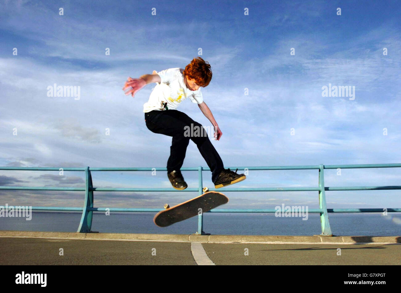 A skateboarder enjoys the warm weather on the seafront at Dun Laoghaire, Ireland. Stock Photo