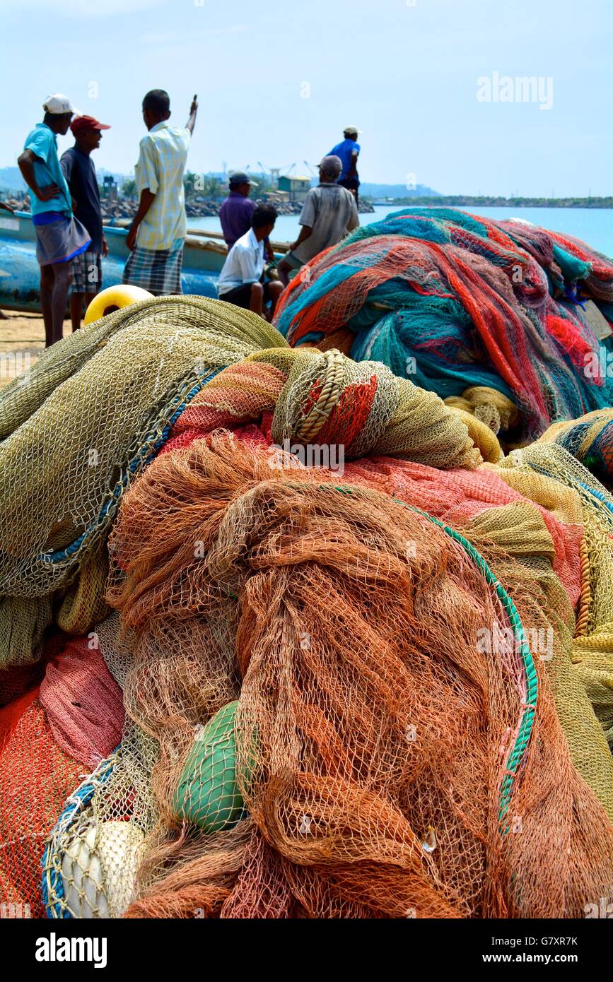 Fishermen with boats and fishing nets on a beach in Galle, Sri Lanka