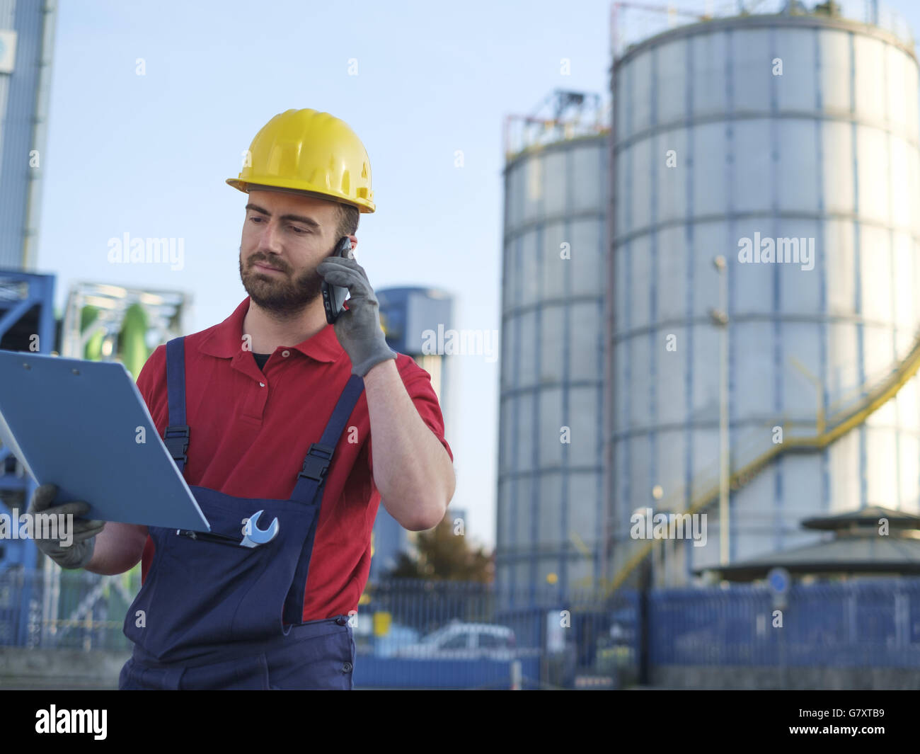 Laborer outside a factory working dressed with safety overalls equipment Stock Photo