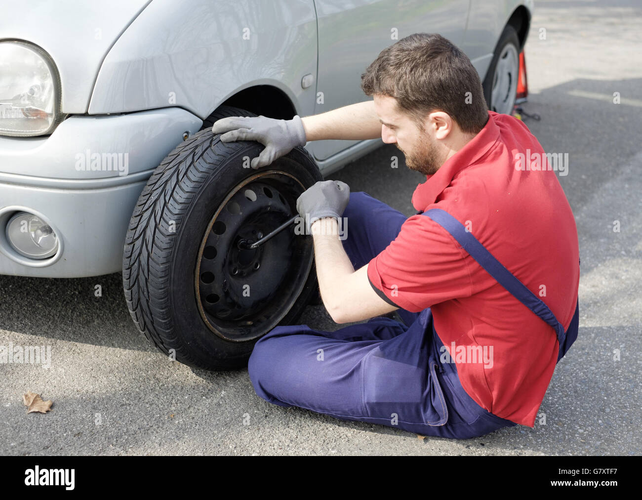 Mechanic fixing a car problem after vehicle breakdown on the road Stock