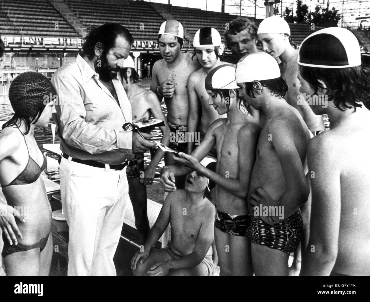 (dpa files) - Italian actor Bud Spencer is crowded by autograph demanding fans at a swimming pool in Munich, Germany, 26 May 1975. Spencer, whose real name is Carlo Pedersoli, studied law and owns a Phd. He took part in the 1952 and 1956 Olympic Games in Helsinki, Finland, and Melbourne, Australia, as a swimmer and water polo player. Spencer who is famous for action movies, was born in Naples, Italy, 31 October 1929. | usage worldwide Stock Photo