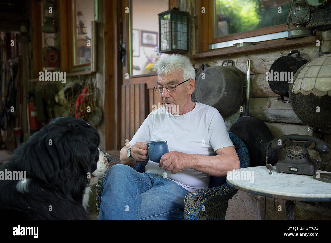 Bockenem, Germany. 22nd June, 2016. Guenther Hamker and his dog Remo in his small house in the forest, near Bockenem, Germany, 22 June 2016. Hamker has been living in a small house in the forest he inherited from his grandfather for 50 years. PHOTO: SWEN PFOERTNER/DPA/Alamy Live News Stock Photo