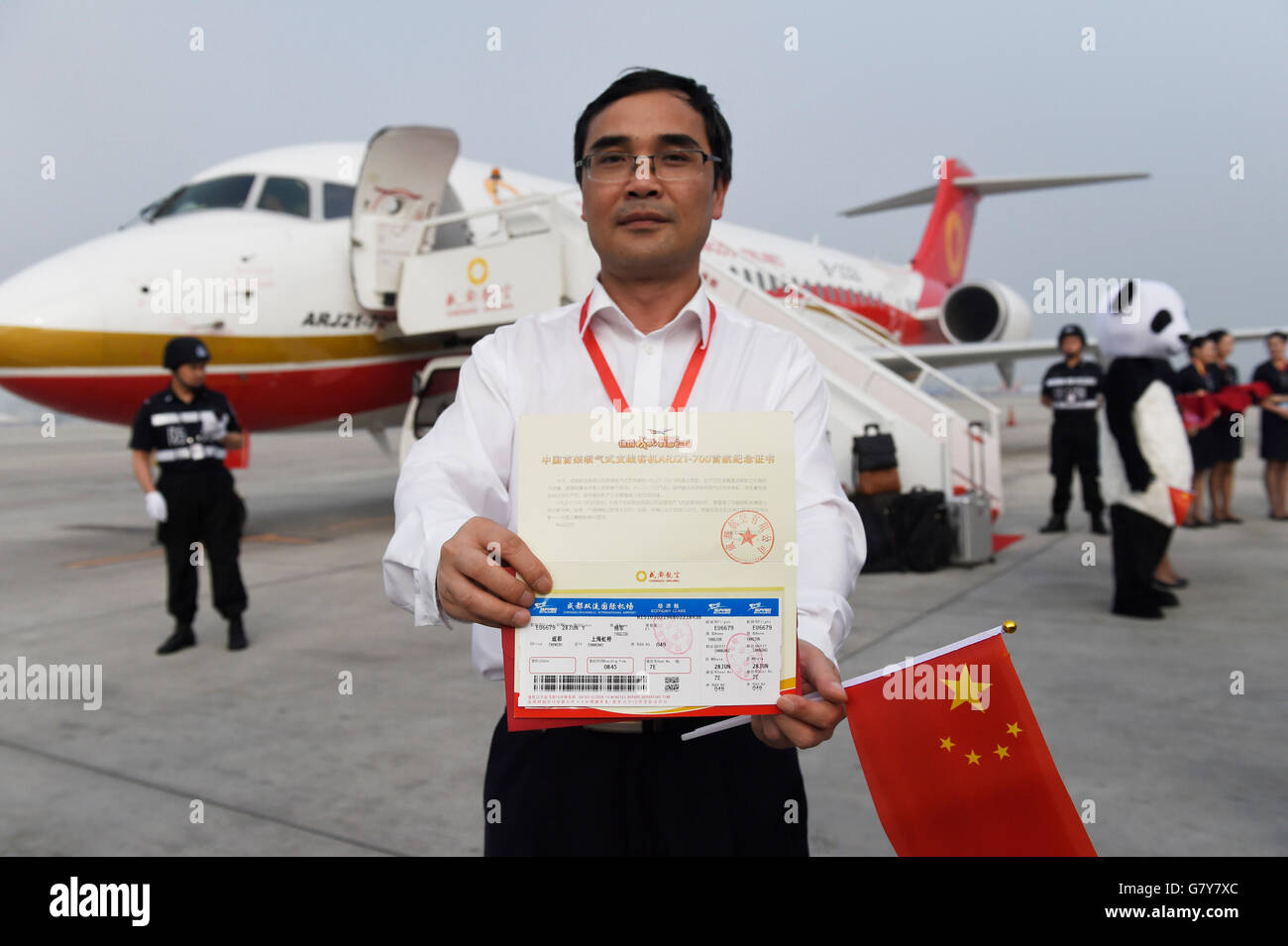 Chengdu, China's Sichuan Province. 28th June, 2016. A passenger shows his boarding pass in front of Chengdu Airlines ARJ21-700 at Shuangliu International Airport in Chengdu, capital of southwest China's Sichuan Province, June 28, 2016. ARJ21, manufactured by the Commercial Aircraft Corp. of China (COMAC), made its maiden commercial flight from Chengdu to Shanghai Tuesday. The domestically-designed airliner is China's first regional jet manufactured according to international standards. © Liu Kun/Xinhua/Alamy Live News Stock Photo