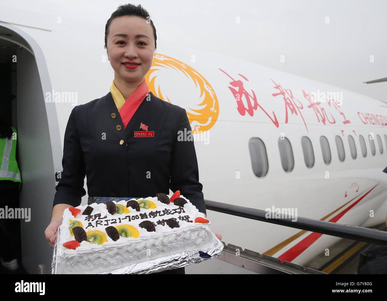 Shanghai, China. 28th June, 2016. A stewardess shows a cake to celebrate the first commercial flight of Chengdu Airlines ARJ21-700 at Hongqiao International Airport in Shanghai, east China, June 28, 2016. ARJ21, manufactured by the Commercial Aircraft Corp. of China (COMAC), made its maiden commercial flight from Chengdu, captial of southwest China's Sichuan Province, to Shanghai on Tuesday. The domestically-designed airliner is China's first regional jet manufactured according to international standards. © Pei Xin/Xinhua/Alamy Live News Stock Photo
