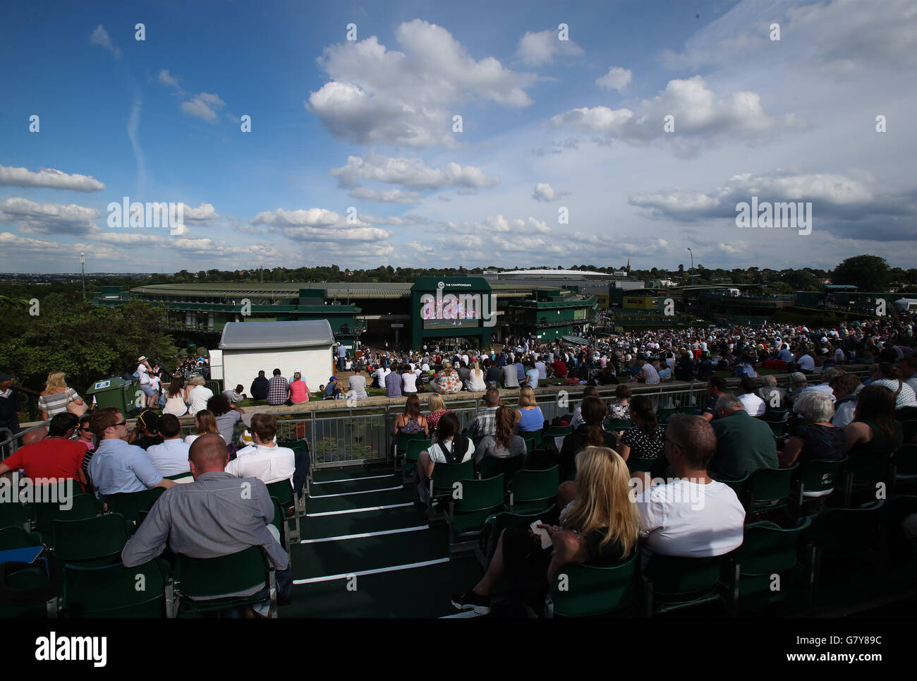 London, UK. 27th June, 2016. Spectators watch a giant screen as they sit on Murray Mount (Henman Hill) on Day 1 at the 2016 Wimbledon Tennis Championships in London June 27, 2016. © Han Yan/Xinhua/Alamy Live News Stock Photo