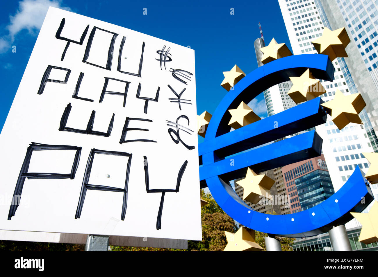 'You play, we pay', poster of the Occupy Frankfurt movement next to the Euro symbol in front of the ECB, European Central Bank Stock Photo