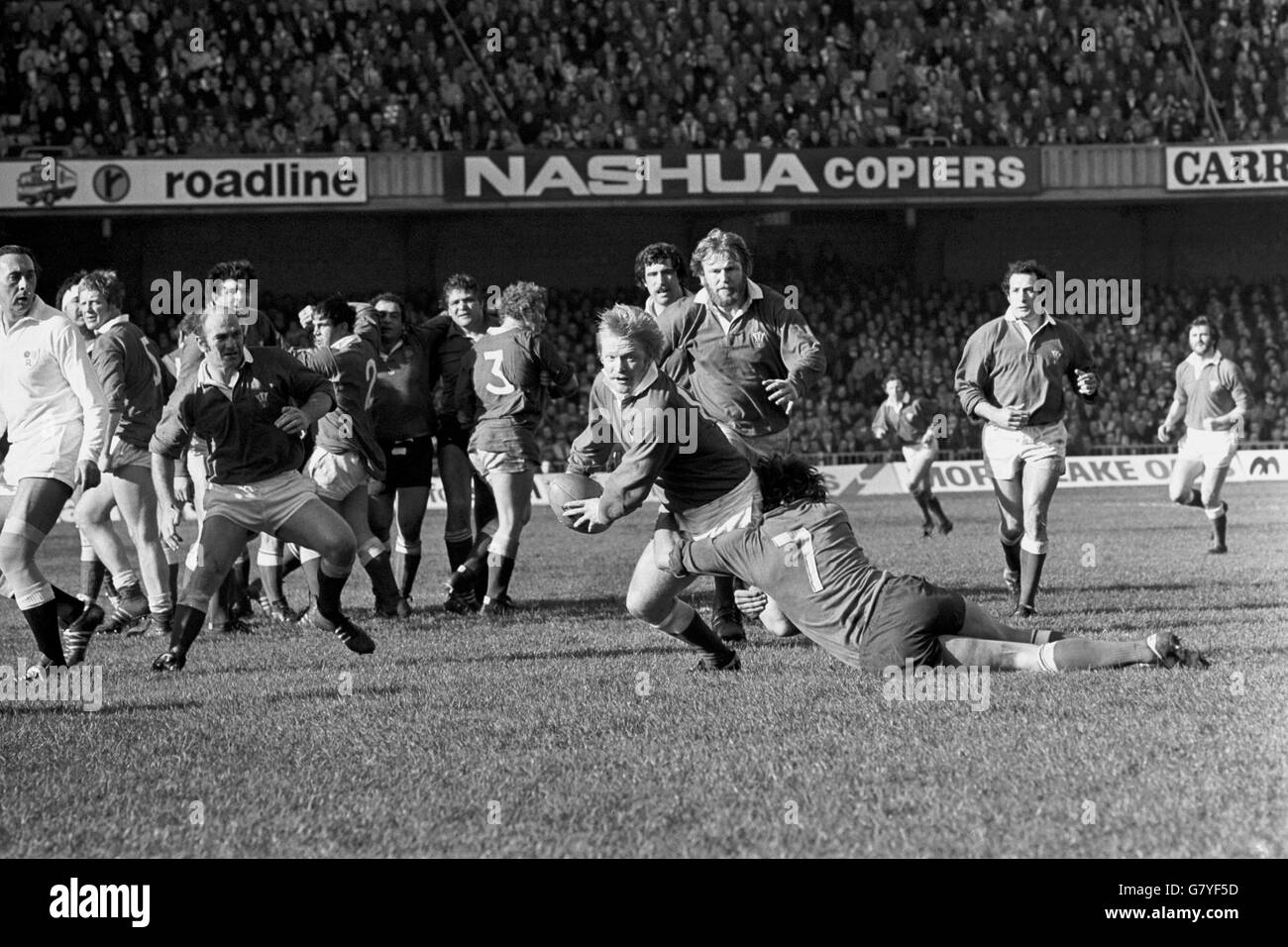 Wales' Steve Fenwick (c, with ball) is tackled by France's Jean-Claude Skrela (7), watched by teammates Terry Cobner (l), Gareth Edwards (r), Derek Quinnell (second r) and Jeff Squire (behind Quinnell) Stock Photo