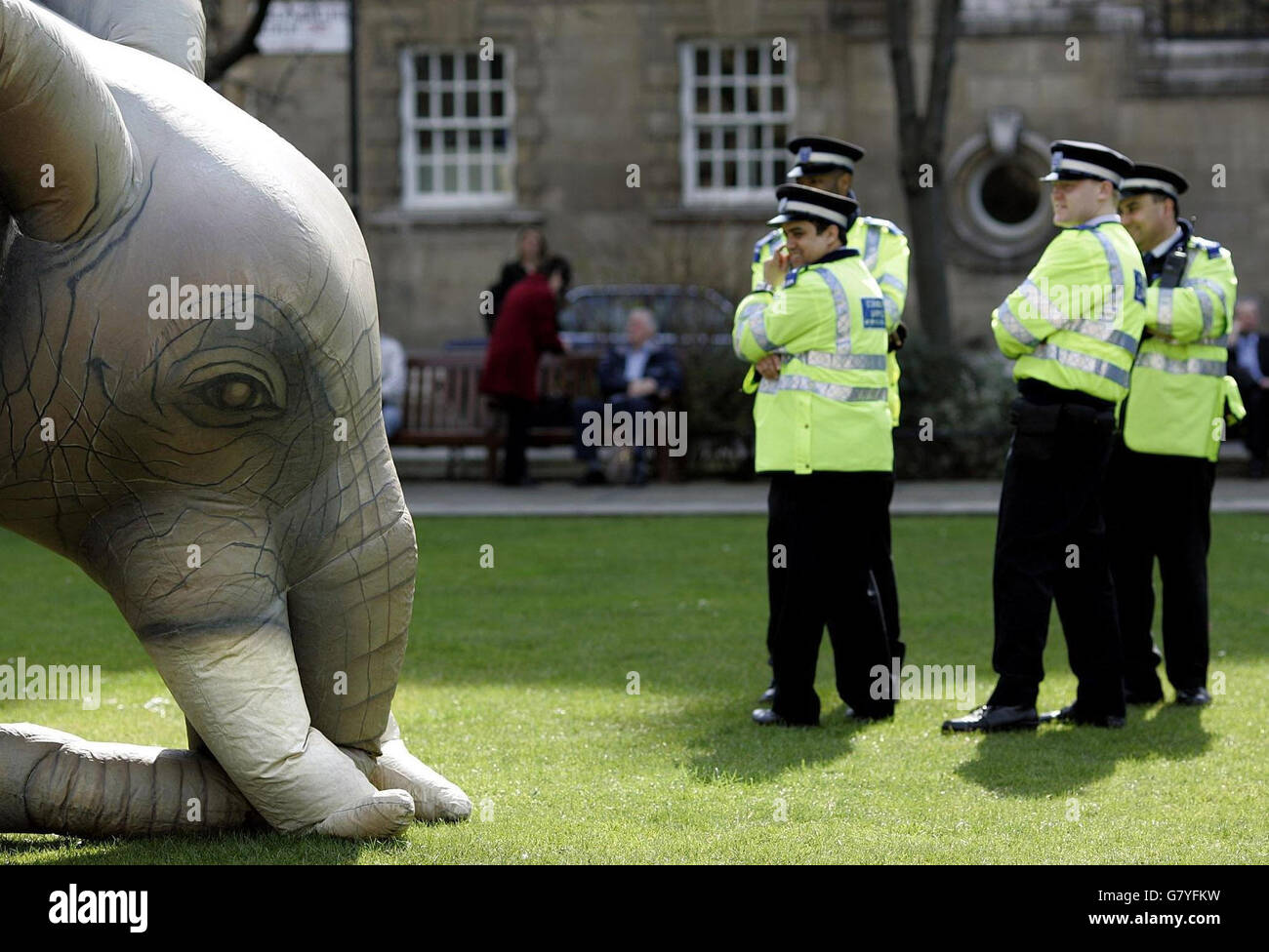 Community Support Officers look on as the demonstrators inflate their never forgetting inflatable elephant on Abindon Green, as hundreds march on Parliament urging MPs to end discrimination against dementia sufferers and their carers. Stock Photo