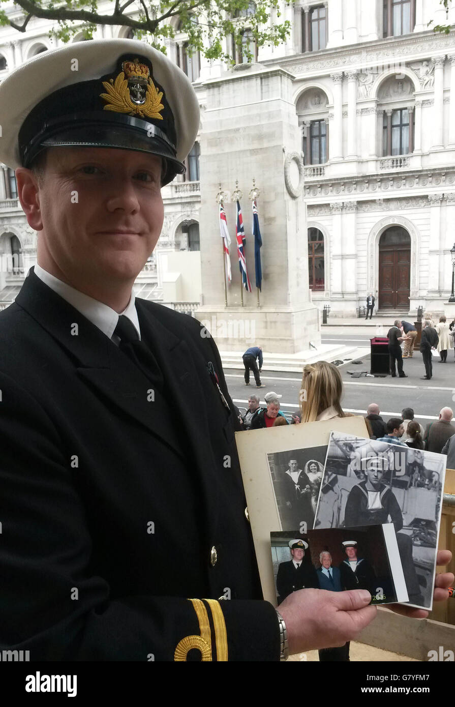 Royal Navy officer Lieutenant Morgan McDonald holds photographs of his grandfather Sinclair 'Mick' West as he attends 70th anniversary of VE Day commemorations at the Cenotaph in Whitehall, London. Stock Photo