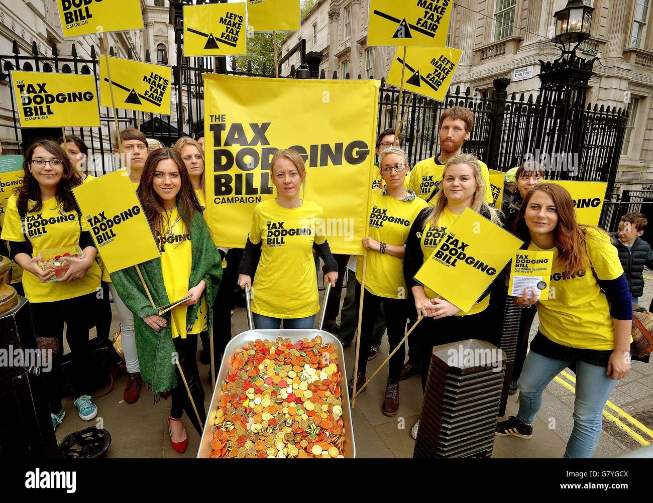 A group of protesters outside Downing Street in Westminster, central London, with wheelbarrows full of chocolate coins to ask the government to crack down on the tax evasion, as they demonstrate again money lost in revenue due to both corporate and individual tax cheats. Stock Photo
