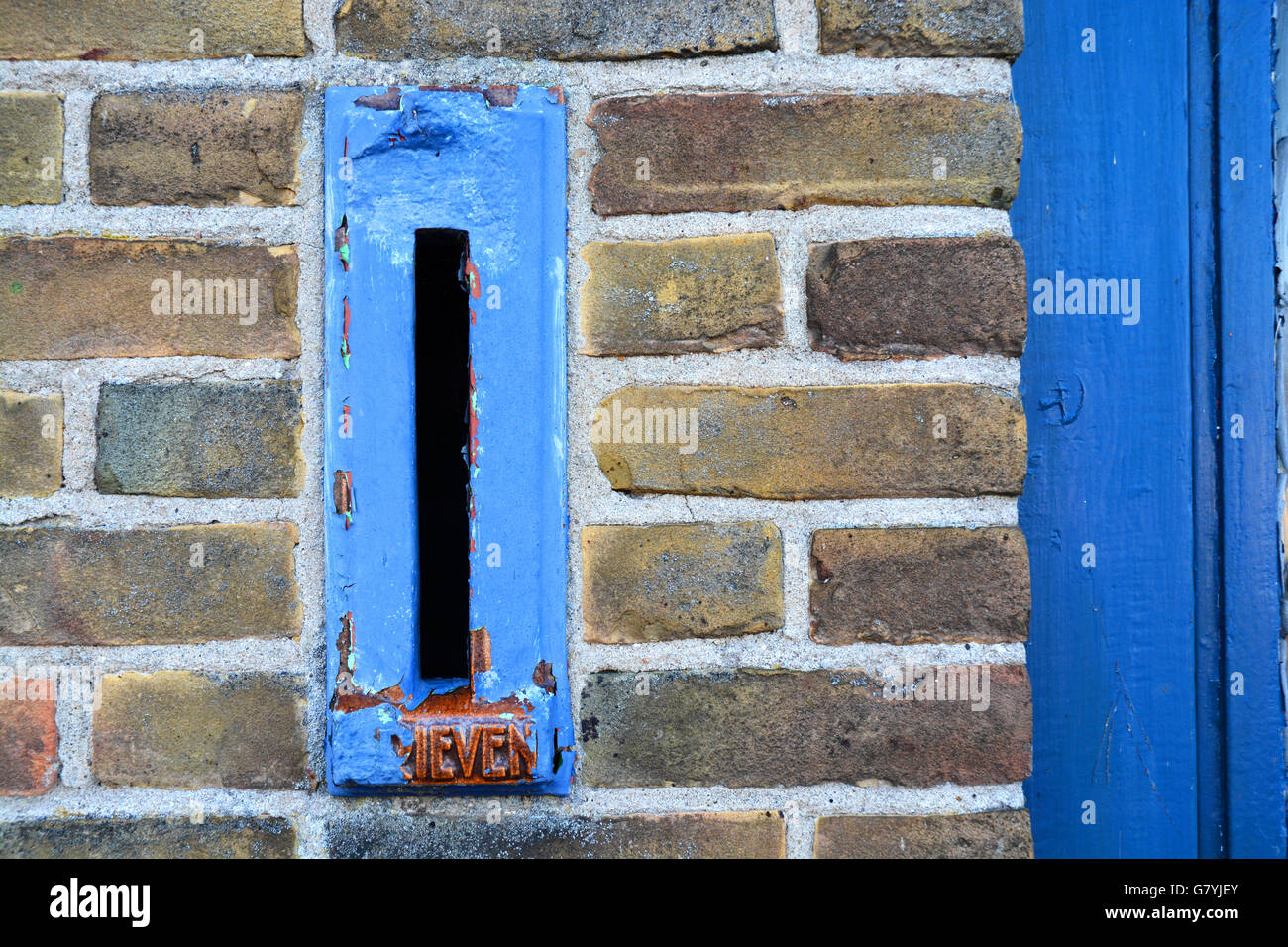 Close up of old blue mailbox in a bricks wall Stock Photo