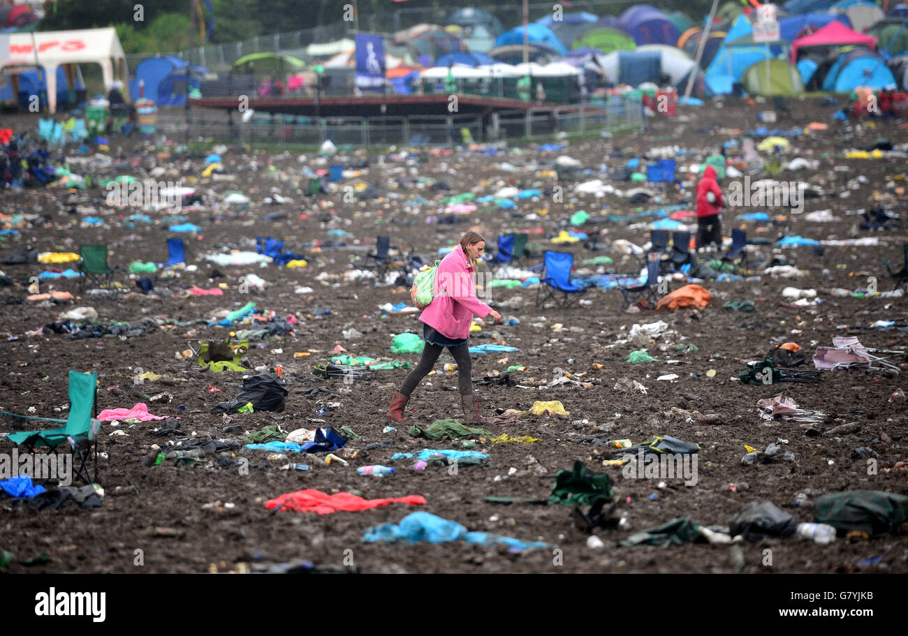 Festivalgoers walk through the aftermatch of Glastonbury Festival, at Worthy Farm in Somerset. Stock Photo