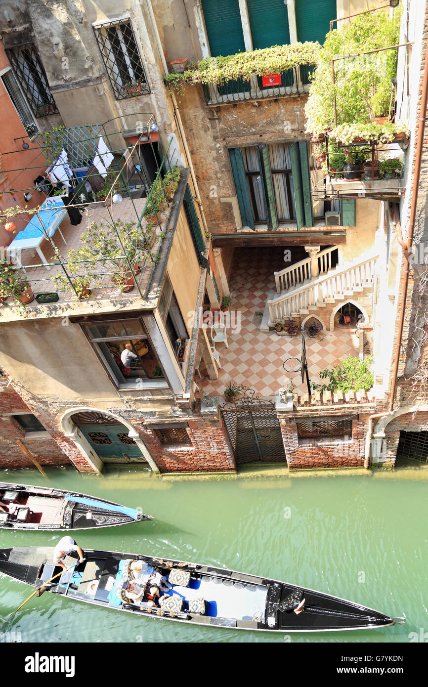 Gondolas crossing Venetian court yard. Canal Rio di Santa Maria Formosa. Stock Photo