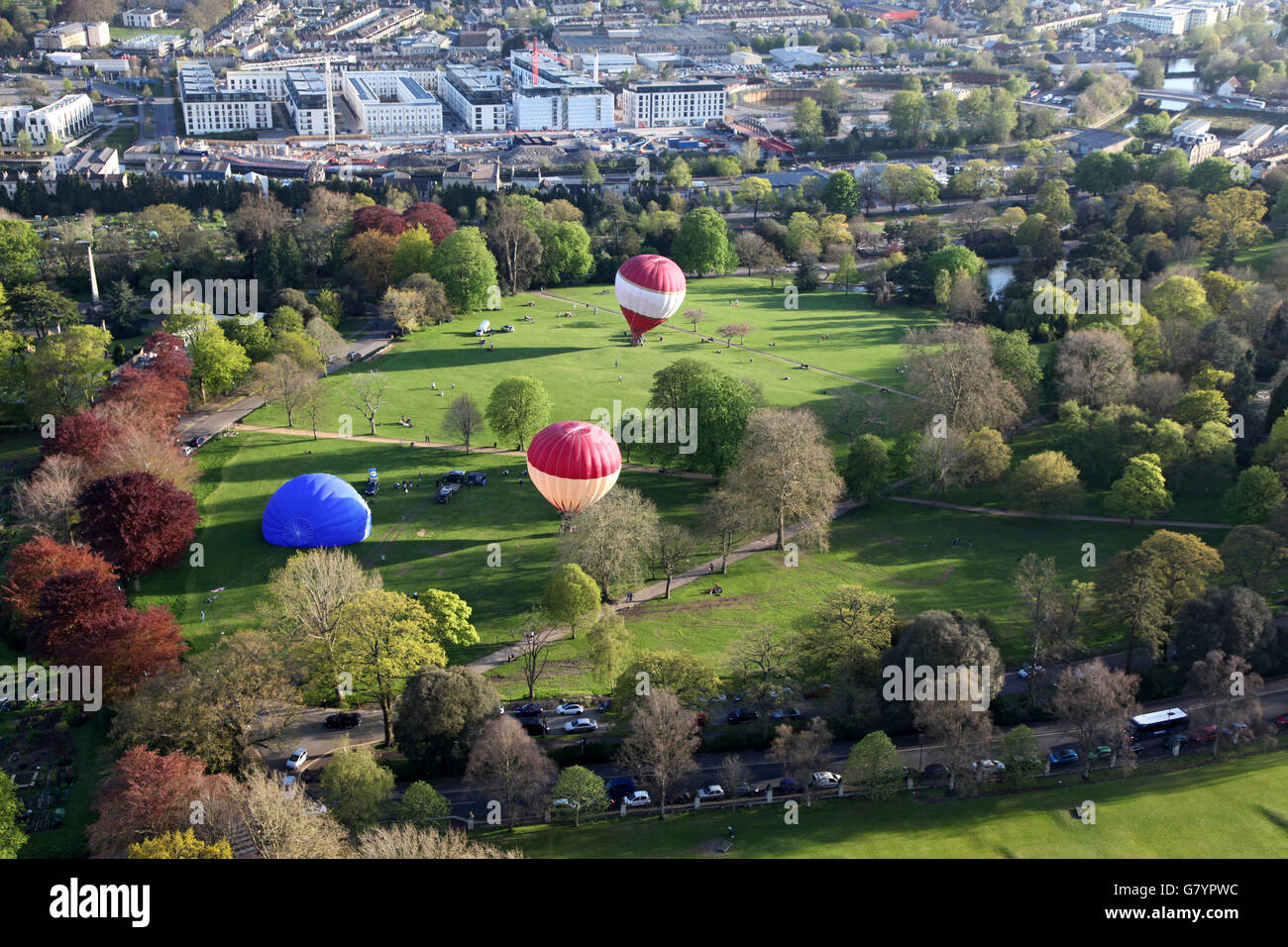 Three hot air balloons are made ready for an sunny evening flight in one of the Bath gardens Stock Photo