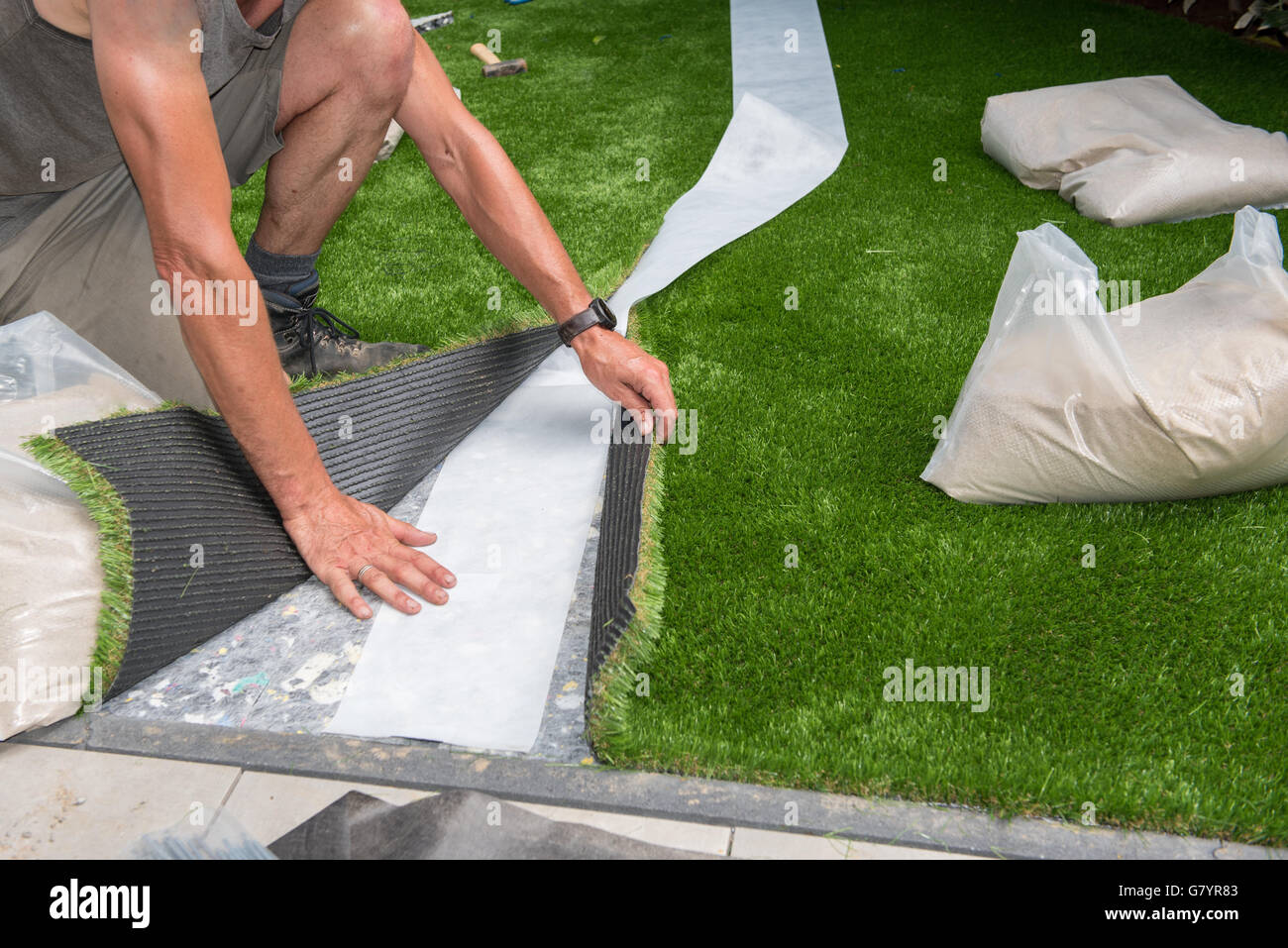 professional gardener is cutting artificial turf to fit Stock Photo