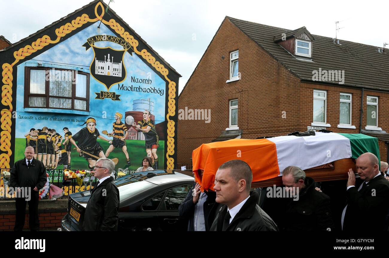 Mourners pause with the coffin of Gerard 'Jock' Davison, a former IRA commander, at the site of his shooting in the Market's Area of Belfast. Stock Photo