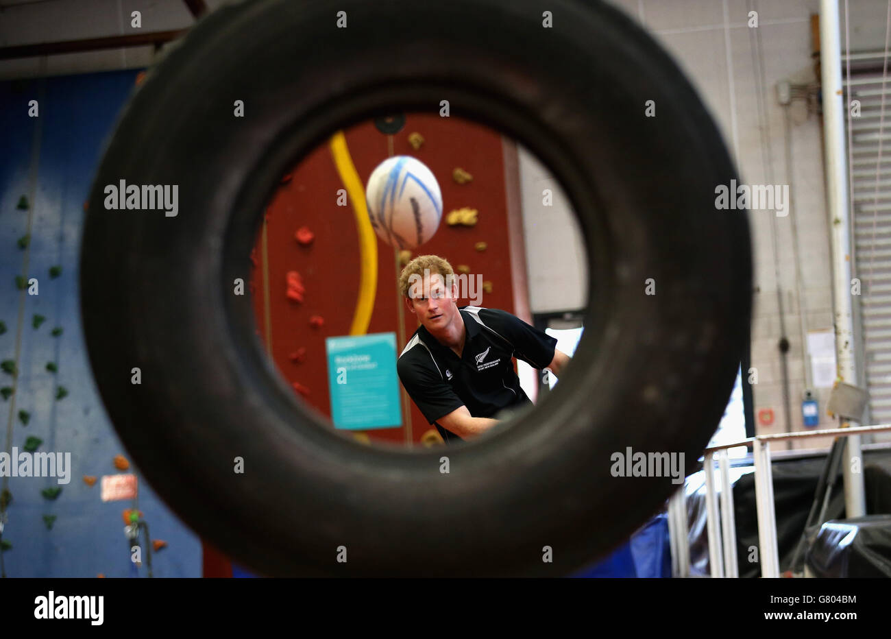 Prince Harry, throwa a rugby ball through a tyre as he takes part in a training excercise at the AUT Millennium Institute of Sport and Health, in Auckland, on the eighth and final day of his visit to New Zealand. Stock Photo