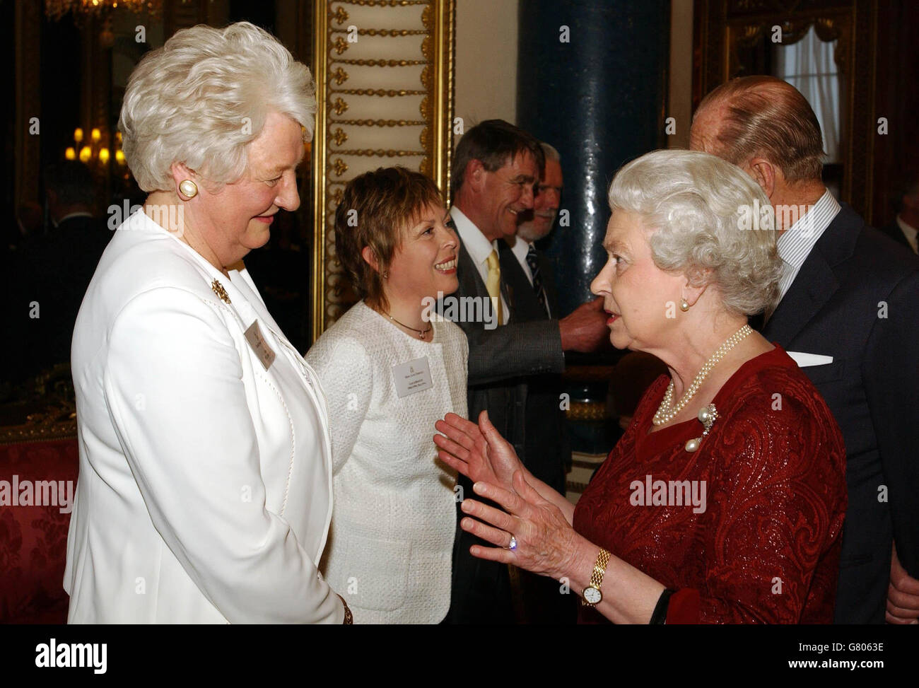 Britain's Queen Elizabeth II talks to Dame Mary Peters who won a Gold Medal in the Pentathlon during the 1972 Munich Olympics, as the Duke of Edinburgh speaks to former gold medallist figure skater Jayne Torville (centre). Stock Photo