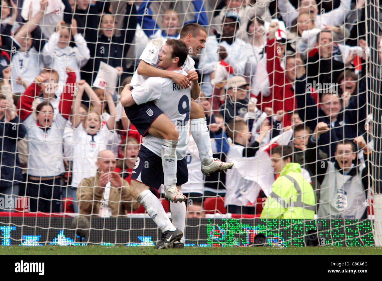 Soccer - FIFA World Cup 2006 Qualifier - Group Six - England v Northern Ireland - Old Trafford. England's Michael Owen (top) celebrates his sides third goal against Northern Ireland with team mate Wayne Rooney. Stock Photo