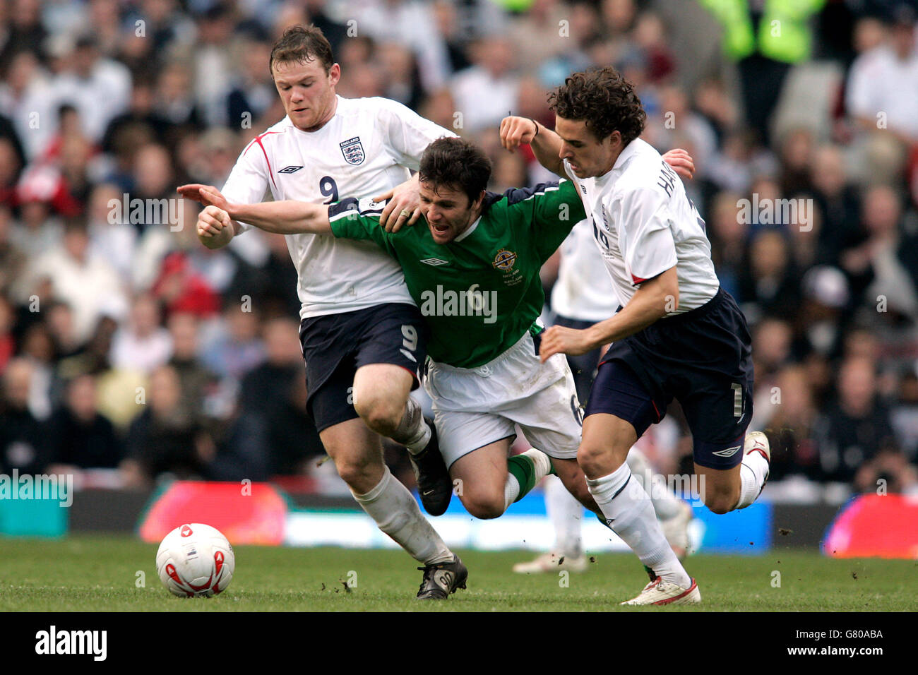 Soccer - FIFA World Cup 2006 Qualifier - Group Six - England v Northern Ireland - Old Trafford. England's Wayne Rooney (L) and Owen Hargreaves (R) battle for the ball with Northern Ireland's Damien Johnson. Stock Photo