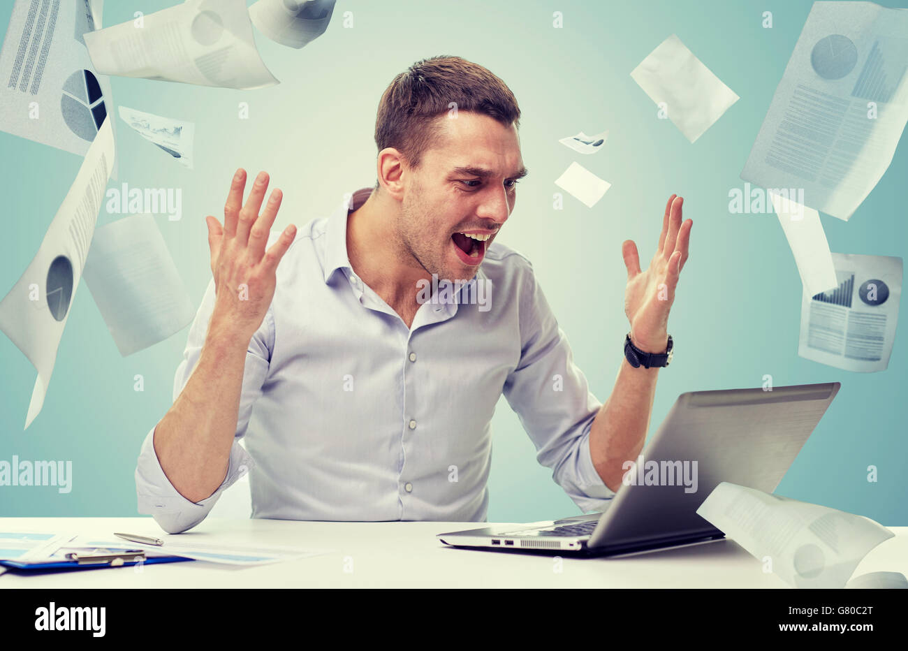 angry businessman with laptop and papers shouting Stock Photo - Alamy