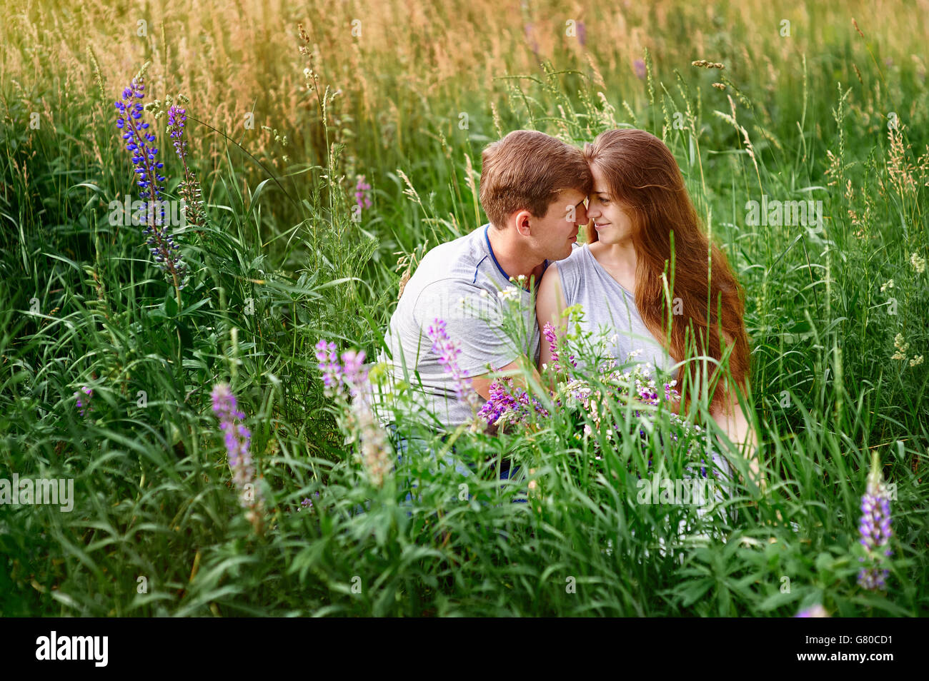 portrait of young stylish fashion couple in field looking on each other Stock Photo