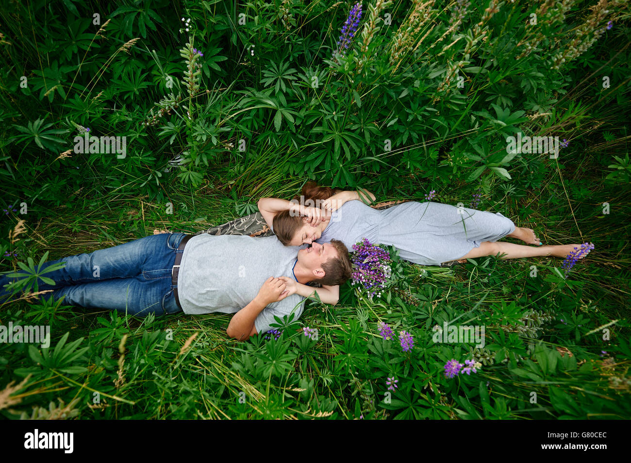 Young couple lying on grass hires