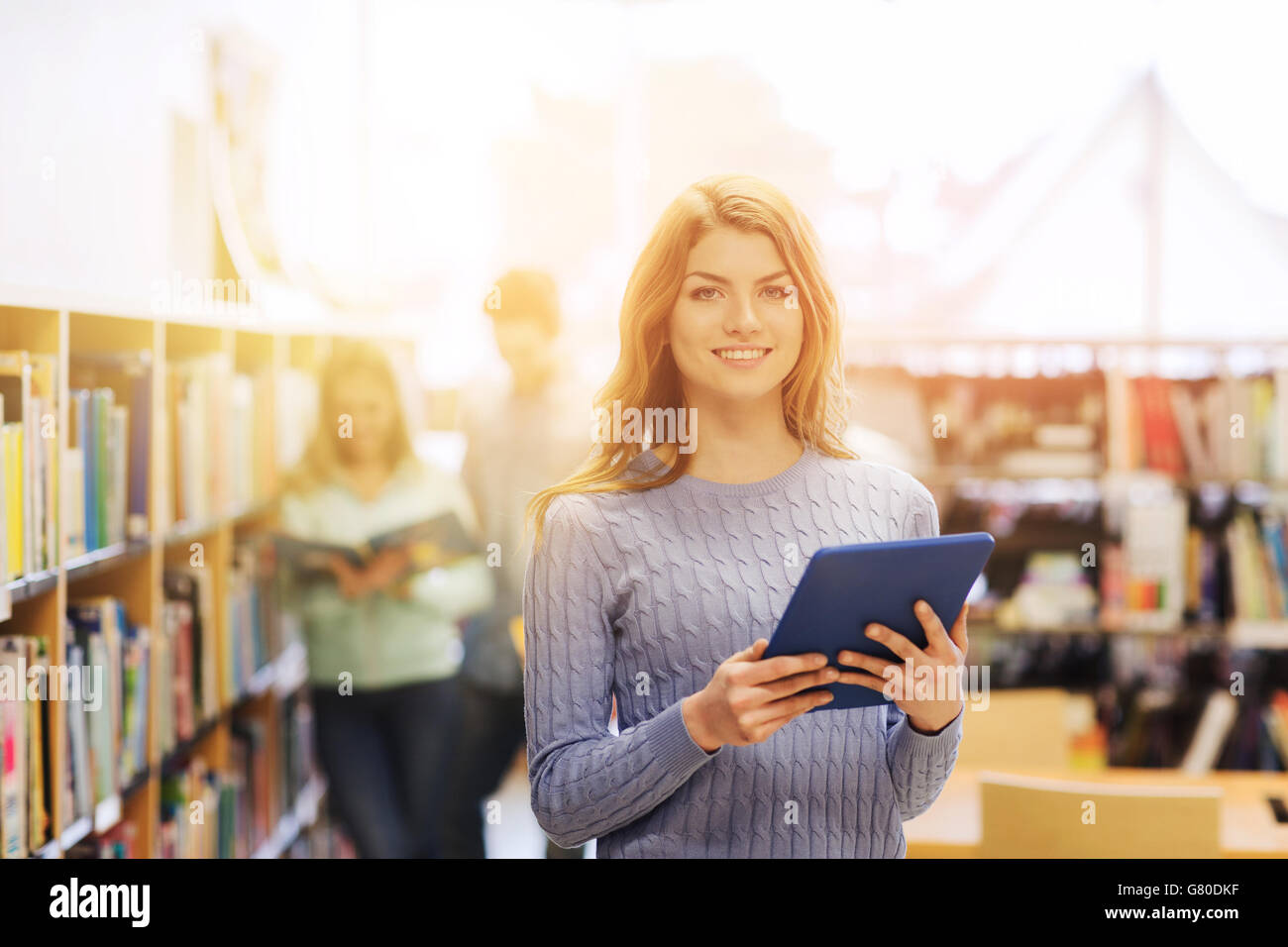 happy student girl with tablet pc in library Stock Photo - Alamy