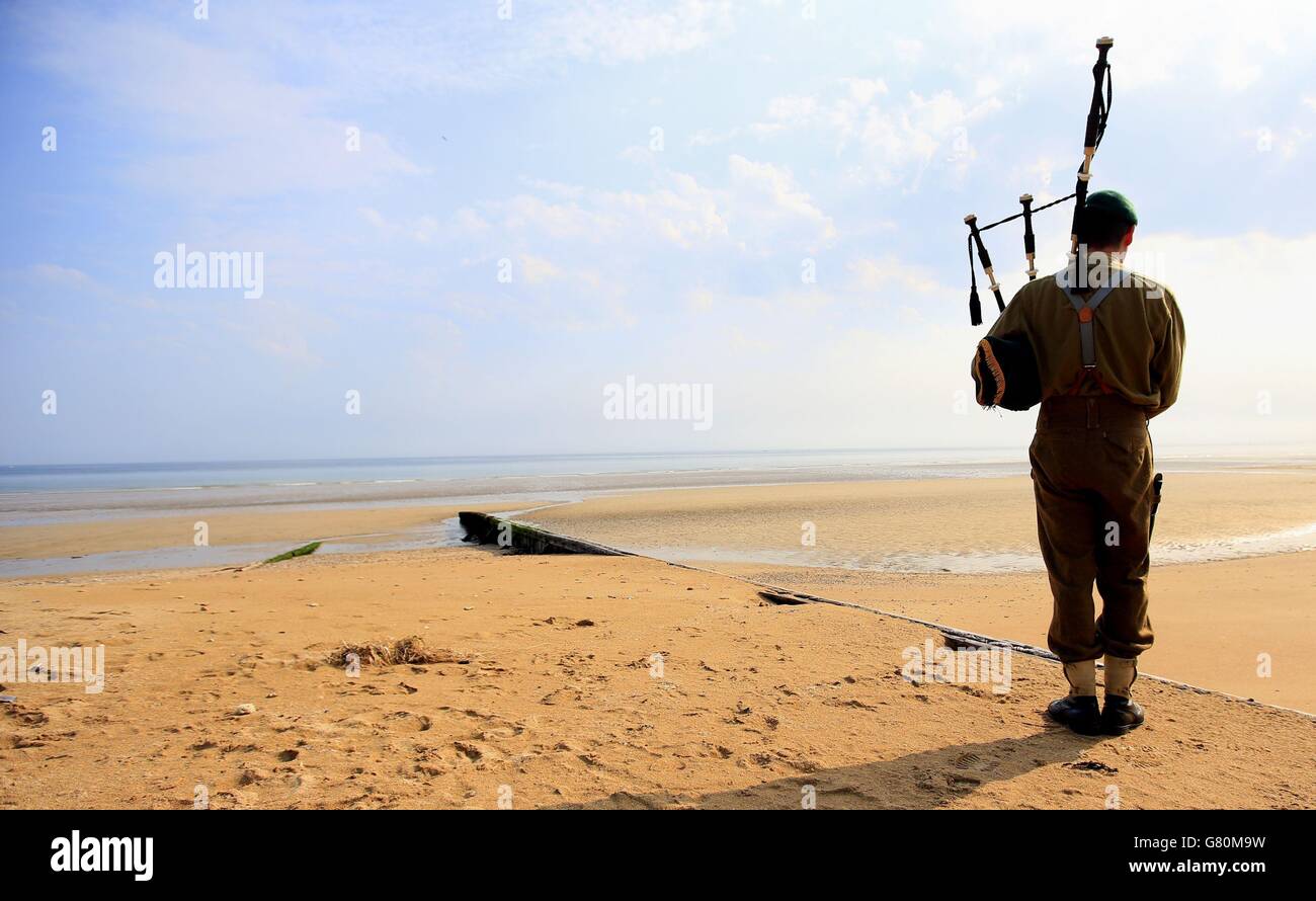A reenactor plays the bagpipes on Sword beach on Normandy, France, as