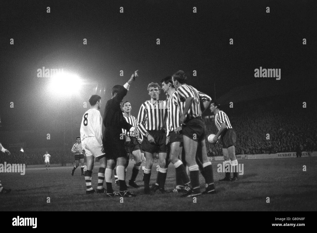 Players crowd round the referee to protest a free kick awarded to