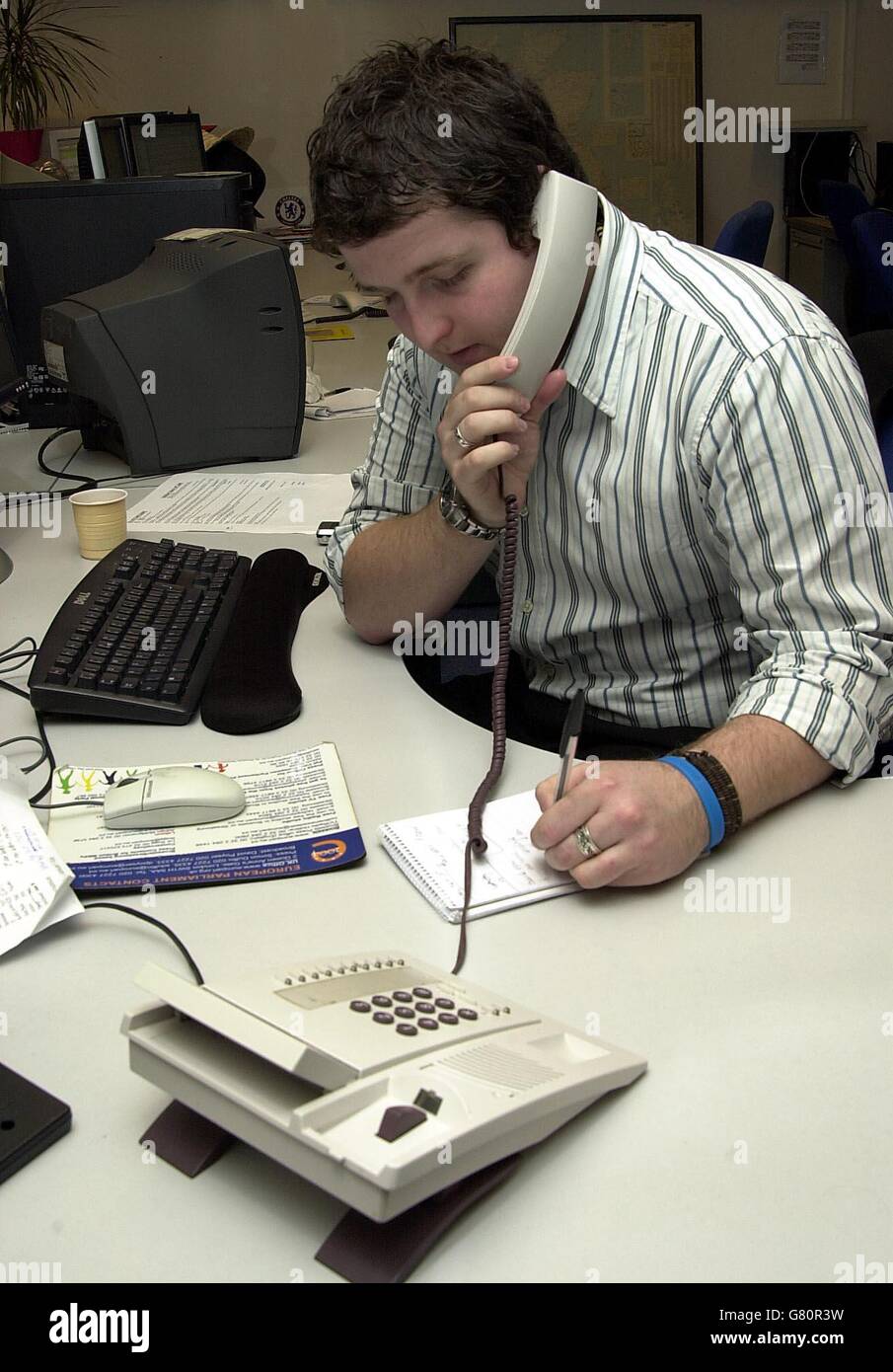 An office worker in London using the telephone as part of their work ...