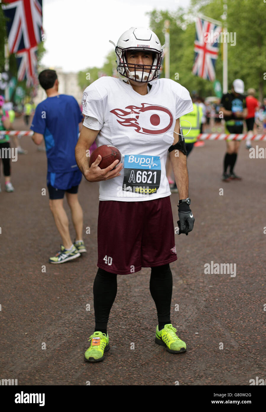 A runner wearing an American Football uniform starting the Bupa London 10,000 along The Mall, in London. Stock Photo