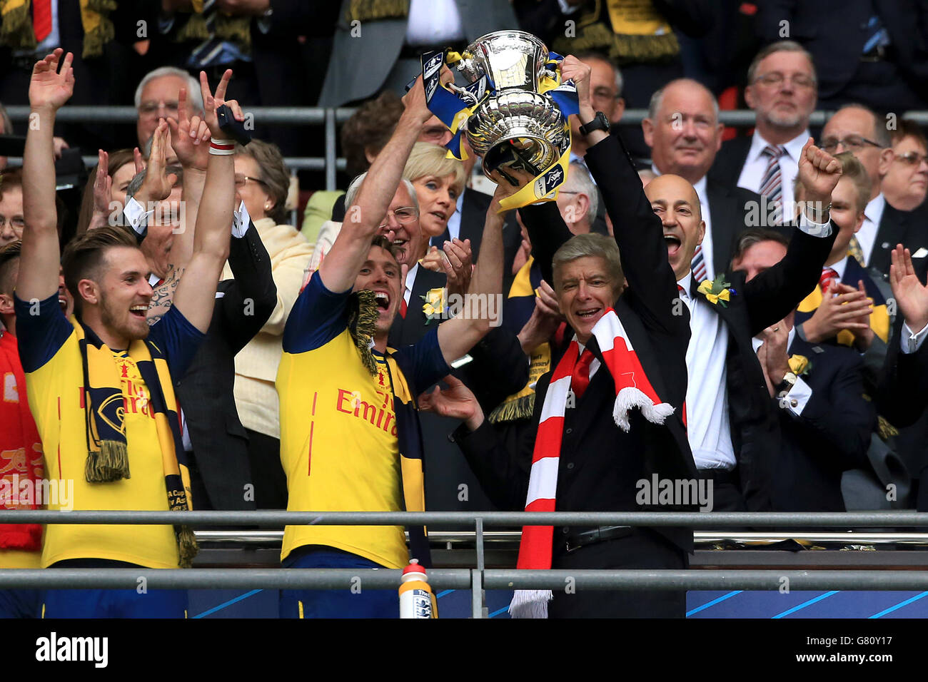 Arsenal's Nacho Monreal (centre left) and manager Arsene Wenger (centre right) celebrate with the trophy on the Wembley balcony following their victory in the FA Cup Final at Wembley Stadium, London. PRESS ASSOCIATION Photo. Picture date: Saturday May 30, 2015. See PA Story SOCCER FA Cup. Photo credit should read: Nick Potts/PA Wire. RESTRICTIONS: Maximum 45 images during a match. No video emulation or promotion as 'live'. No use in games, competitions, merchandise, betting or single club/player services. No use with unofficial audio, video, data, fixture Stock Photo