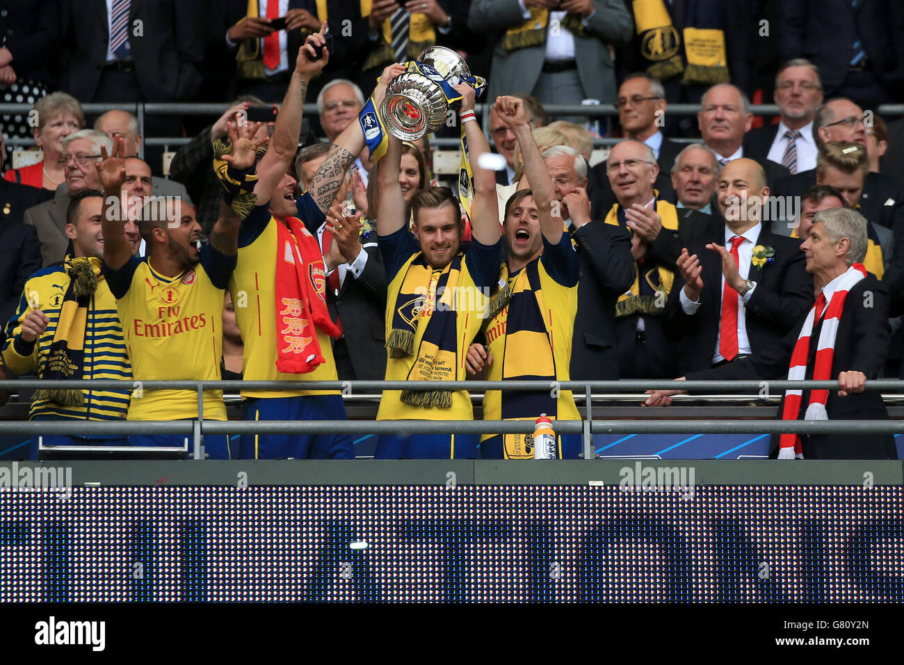 Arsenal's Aaron Ramsey (centre) and Nacho Monreal (centre right) celebrate with the trophy on the Wembley balcony following their victory in the FA Cup Final at Wembley Stadium, London. PRESS ASSOCIATION Photo. Picture date: Saturday May 30, 2015. See PA Story SOCCER FA Cup. Photo credit should read: Nick Potts/PA Wire. RESTRICTIONS: Maximum 45 images during a match. No video emulation or promotion as 'live'. No use in games, competitions, merchandise, betting or single club/player services. No use with unofficial audio, video, data, fixture Stock Photo