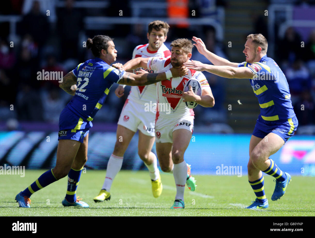 St. Helens Tom Makinson is tackled by Warrington's Gene Ormsby and Ben Currie during the Magic Weekend match at St James' Park, Newcastle. Stock Photo