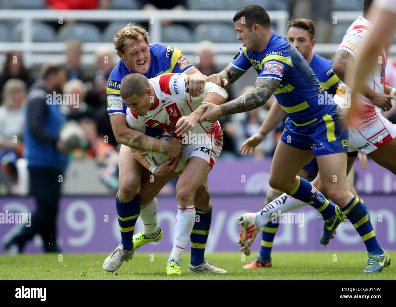 St. Helens Travis Burns is tackled by Warrington's Chris Hill during the Magic Weekend match at St James' Park, Newcastle. Stock Photo