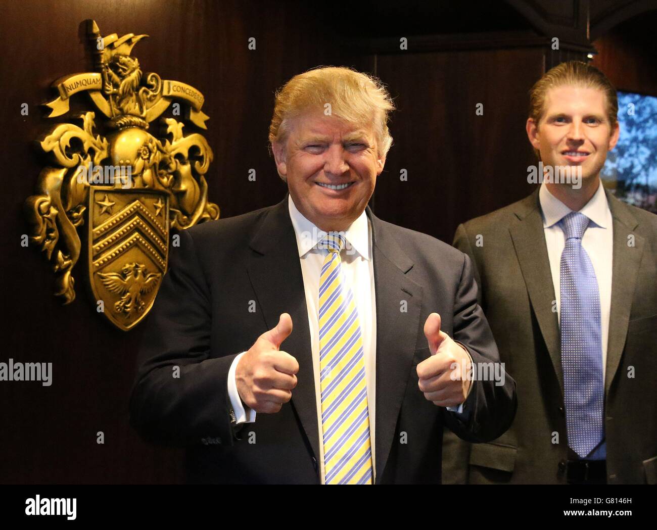 Donald Trump and his son Eric (right) stand next to the family crest after  unveiling the multi-million pound refurbishment of the Trump Turnberry  clubhouse at his golf course in south Ayrshire Stock