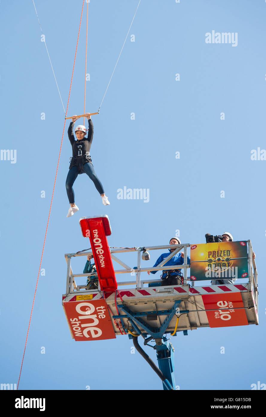 Prized Apart presenter Emma Willis jumps from a 25 metre high platform onto a trapeze outside BBC Broadcasting House, London, to mark the launch of new BBC Saturday night entertainment show Prized Apart. Stock Photo