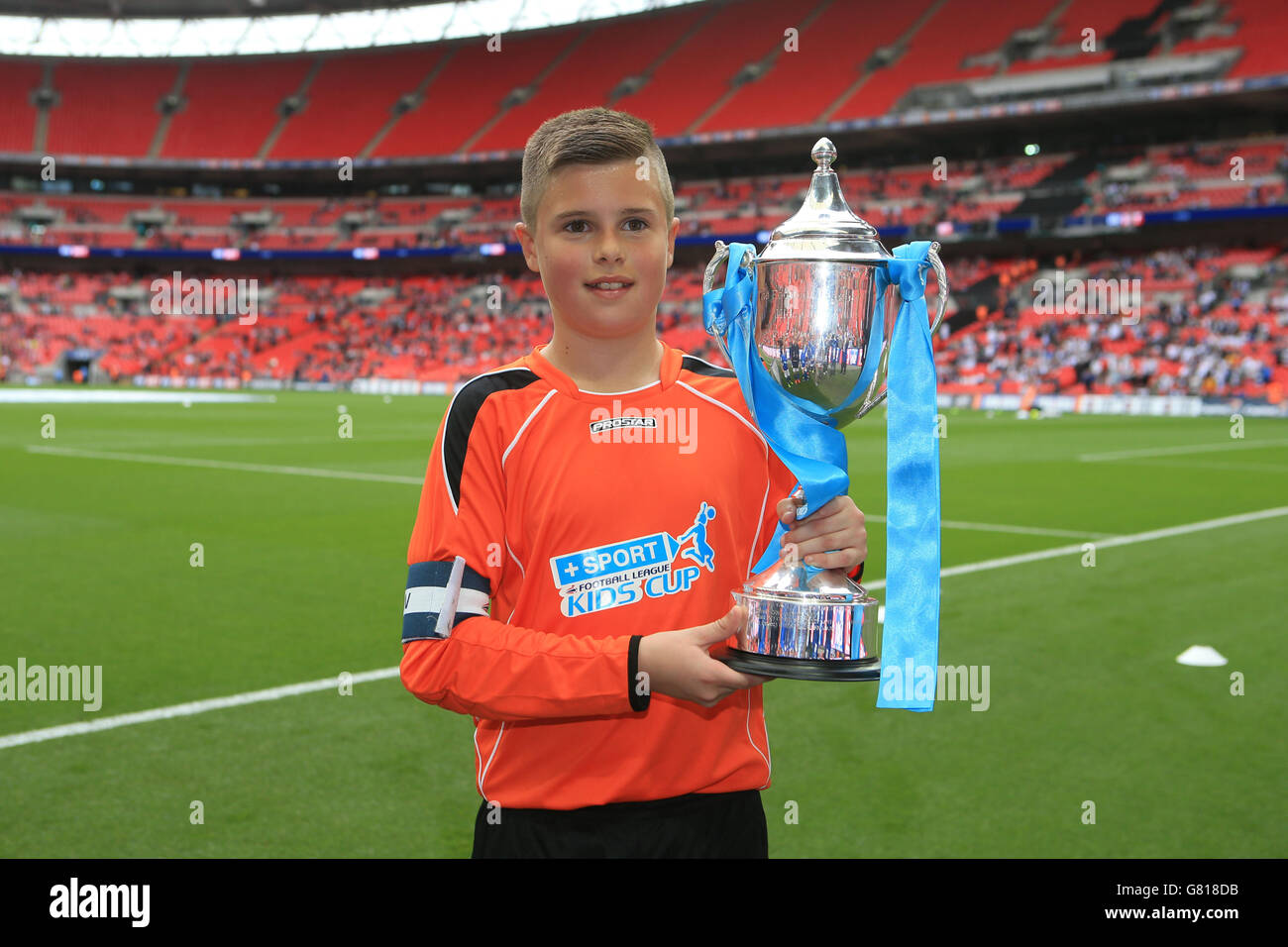 Oldham Athletic's captain represented by South Failsworth Primary school holds the trophy for winning the Kinder+Sport Kids Cup Final. Stock Photo