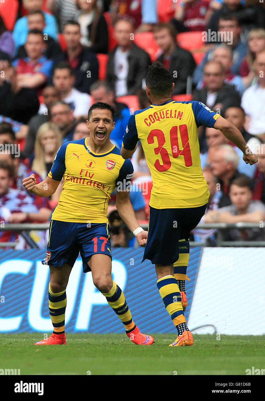Arsenal's Alexis Sanchez celebrates scoring their second goal of the game with team-mate Francis Coquelin (right) during the FA Cup Final at Wembley Stadium, London. PRESS ASSOCIATION Photo. Picture date: Saturday May 30, 2015. See PA Story SOCCER FA Cup. Photo credit should read: Nick Potts/PA Wire. RESTRICTIONS: Maximum 45 images during a match. No video emulation or promotion as 'live'. No use in games, competitions, merchandise, betting or single club/player services. No use with unofficial audio, video, data, fixture Stock Photo