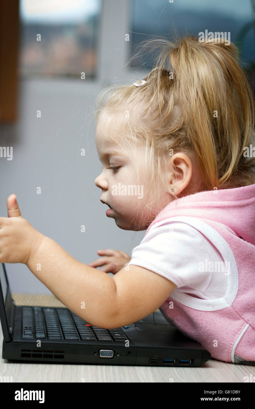 Little girl using laptop for bussines figures, data sheet Stock Photo