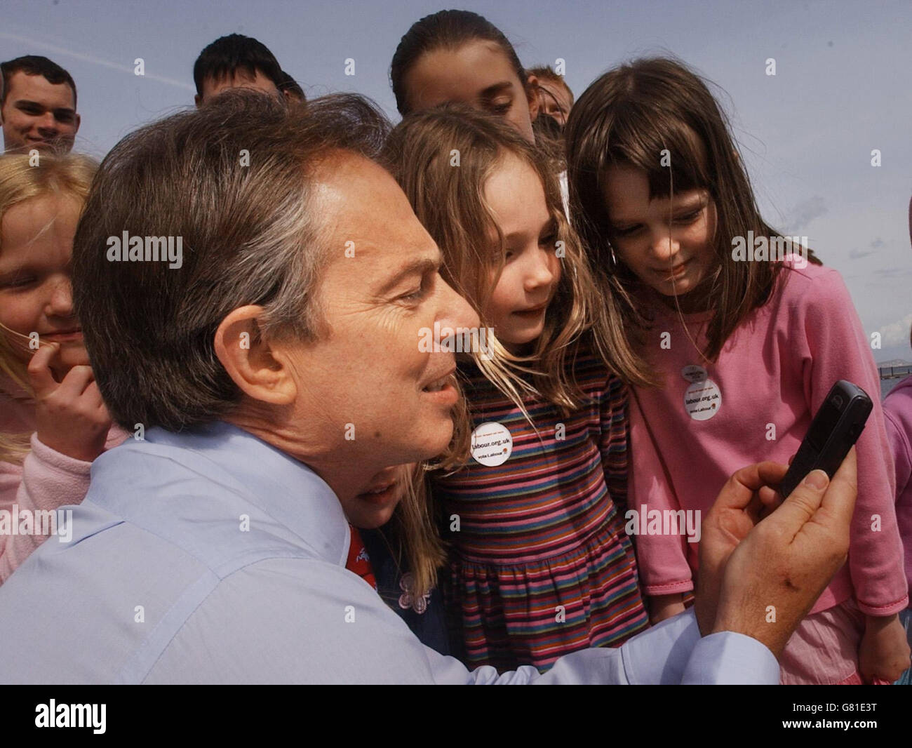 Britain's Prime Minister Tony Blair shows local children pictures he