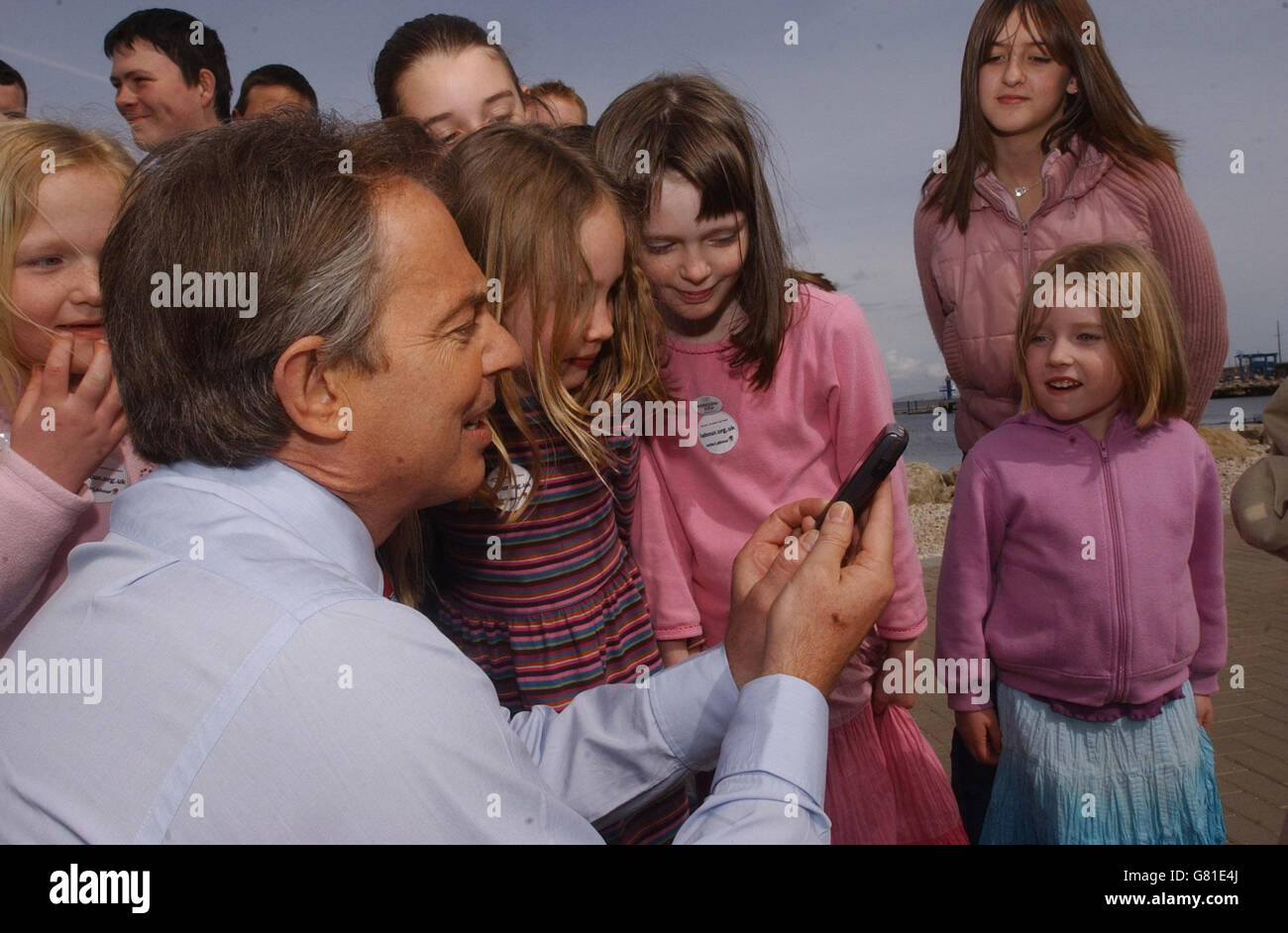 Britain's Prime Minister Tony Blair shows local children pictures he