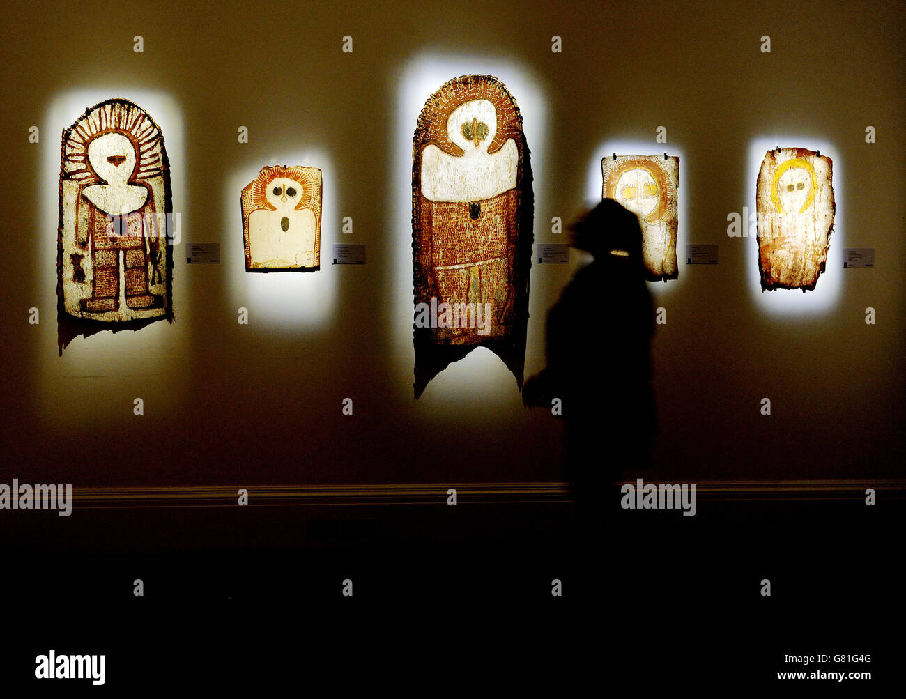 A visitor looks at Wanjina (Austral Gothic) beings, painted on tree bark, during a preview for Sotheby's 'Aboriginal Art' sale, the first Sotheby's London sale of Aboriginal art which will take place on 10th June at Sotheby's, New Bond Street, London. Stock Photo