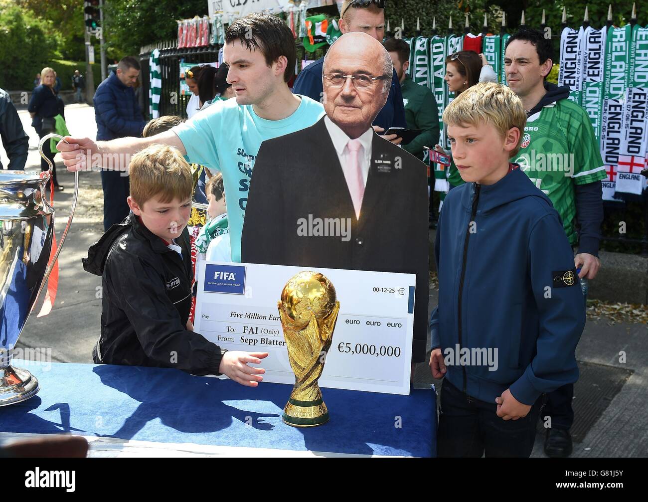 Fans stand with a cardboard cut out of Sepp Blatter beforeduring the