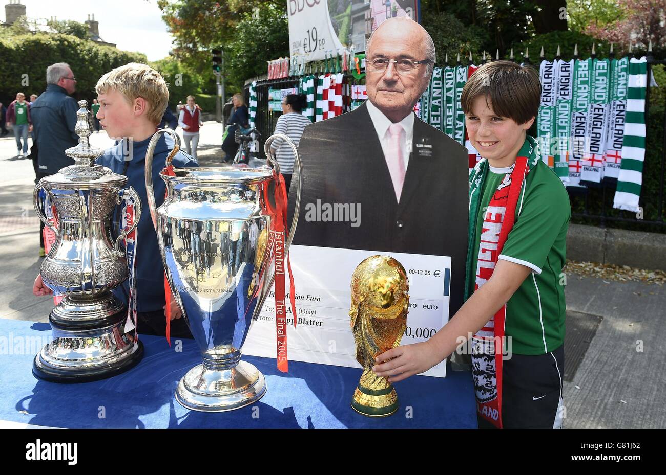 Fans stand with a cardboard cut out of Sepp Blatter beforeduring the