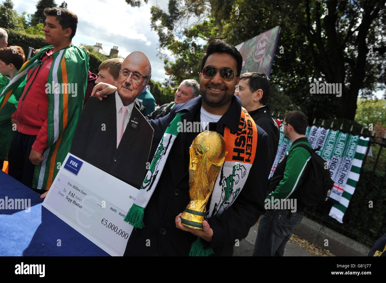 Football fans stand with a cardboard cutout of Sepp Blatter ahead of