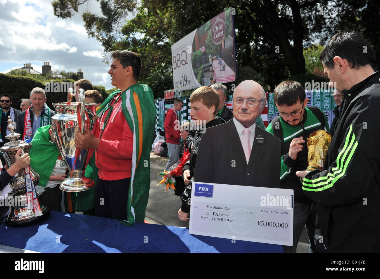 Football fans stand with a cardboard cutout of Sepp Blatter ahead of