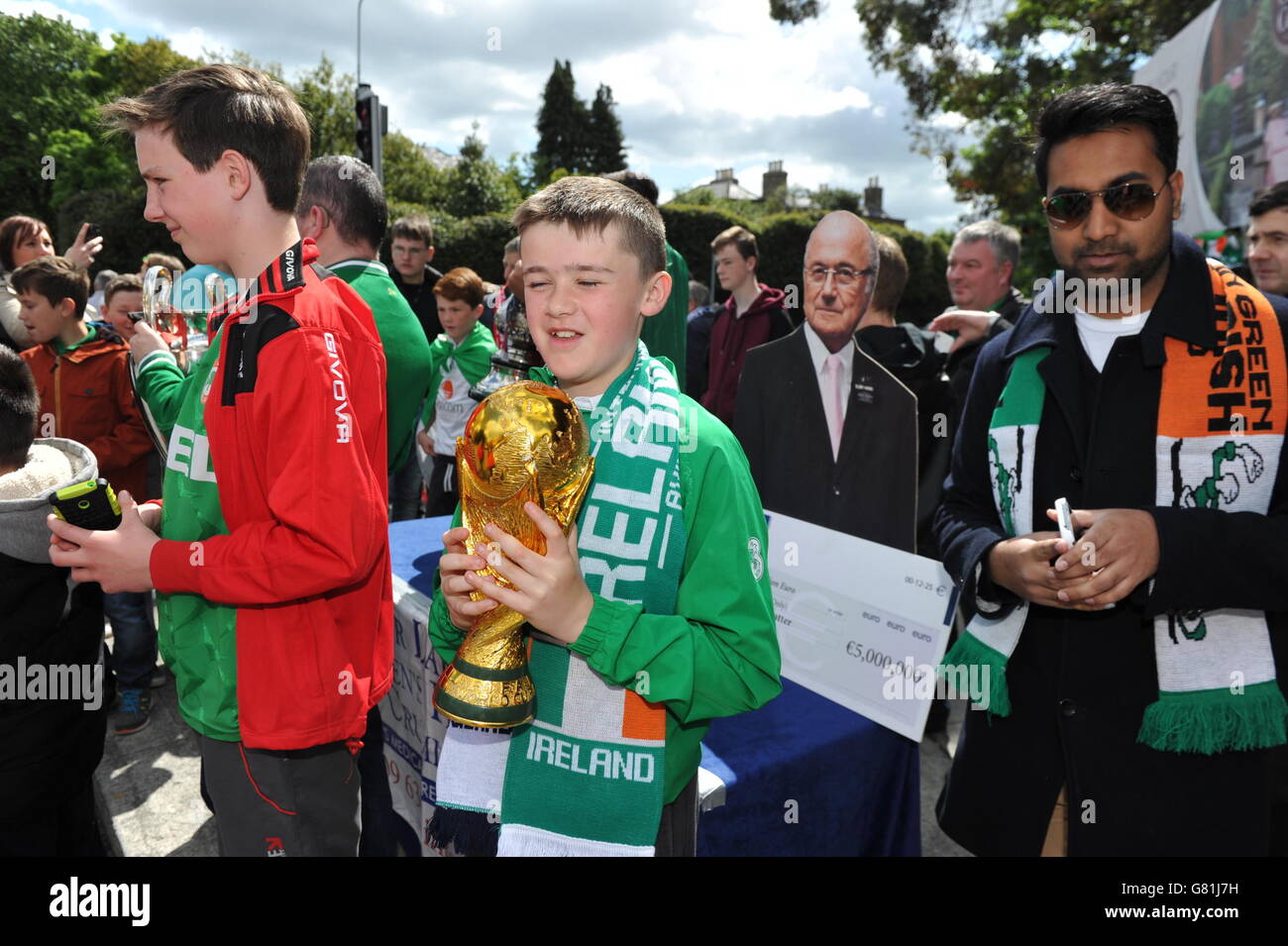 Football fans stand with a cardboard cutout of Sepp Blatter ahead of