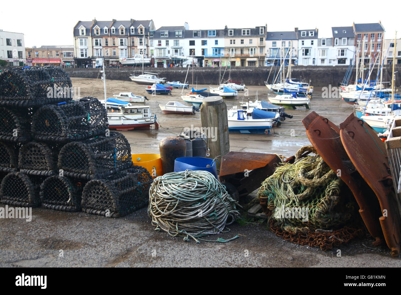 Lobster pots and other fishing equipment stacked on the quay at Ilfracombe awaiting loading the next fishing boat. Stock Photo